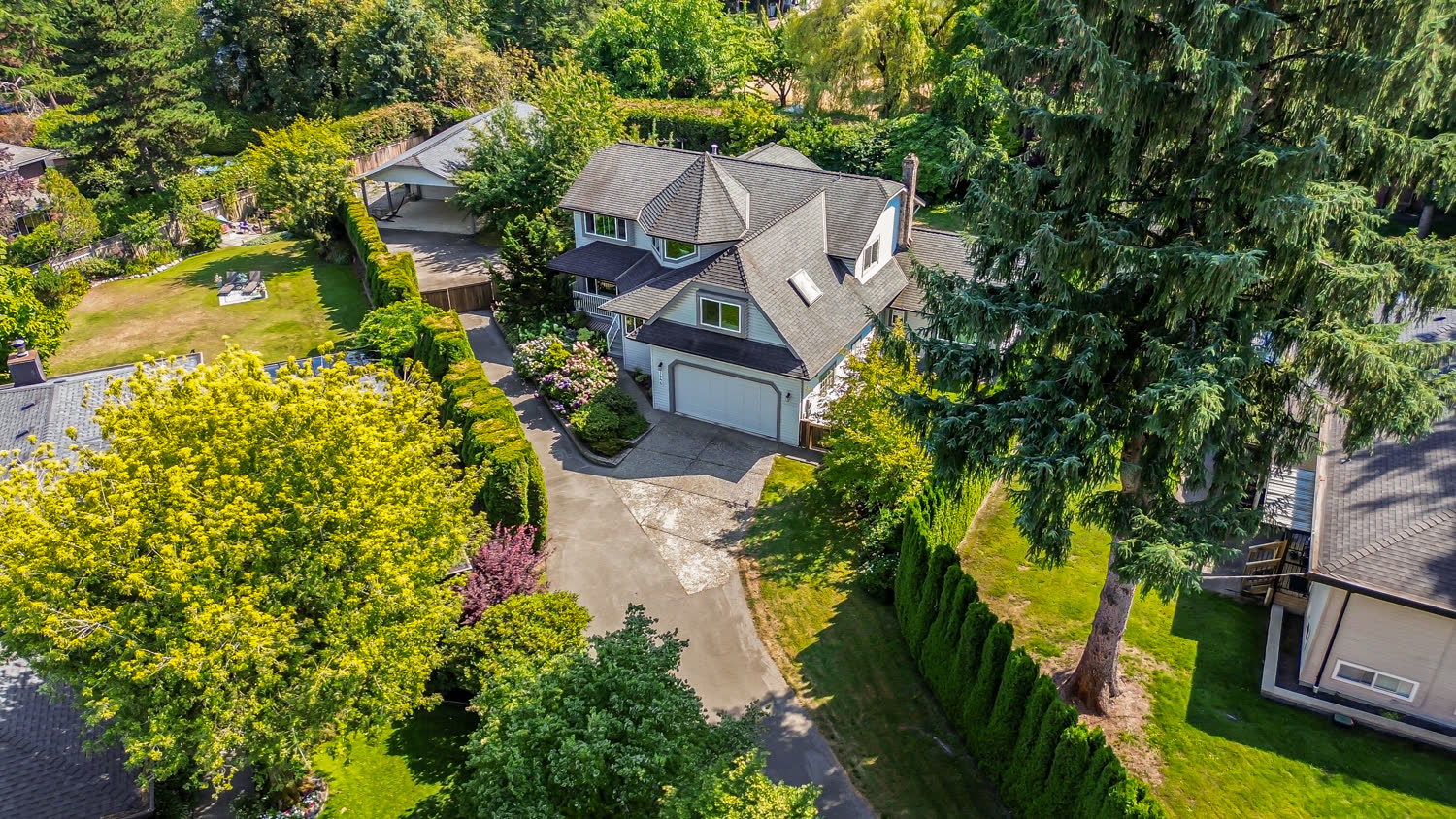 Aerial drone photo of a house and lot surrounded by mature trees