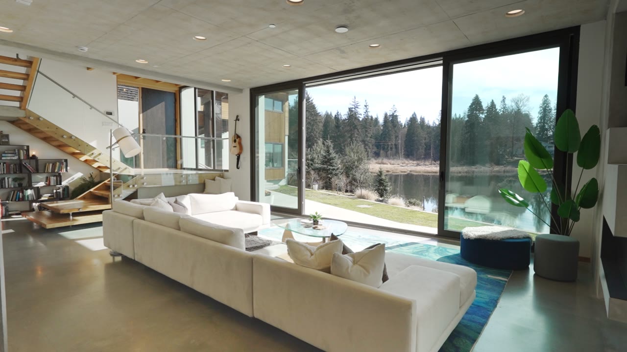 Living room with floor-to-ceiling windows overlooking a lake